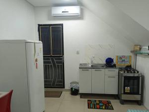 a kitchen with a white refrigerator and a stove at loft 01 Manaus in Manaus