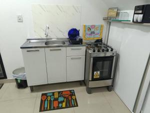 a small kitchen with a sink and a stove at loft 01 Manaus in Manaus +8 photos
