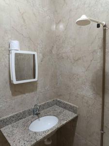 a bathroom with a sink and a mirror at loft 01 Manaus in Manaus