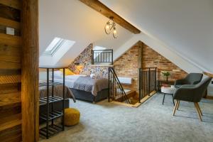 a loft bedroom with a bed and a chair at Apartamenty Pod Bocianem in Muszyna