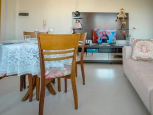 a living room with a table and a chair and a couch at Apartamento perto UEM Wi-Fi MN701 in Maringá