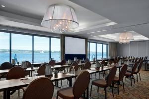 a dining room with tables and chairs and windows at Halifax Marriott Harbourfront Hotel in Halifax +97 photos