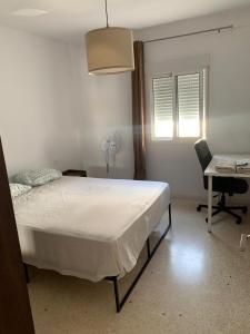sypialnia z łóżkiem, biurkiem i krzesłem w obiekcie Casa Amapola - Costa Bahía de Cádiz w mieście Puerto Real