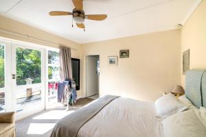 a bedroom with a bed and a ceiling fan at Delightfully Casual & Spacious in Cape St Francis +29 photos