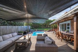 a patio with a couch and a table and a pool at Delightfully Casual & Spacious in Cape St Francis