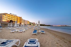 ein Strand mit Liegestühlen und Sonnenschirmen und das Meer in der Unterkunft Perla Apartments in Nessebar
