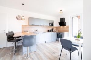 a kitchen with white cabinets and a table and chairs at Steife Brise Nr 2 in Neustadt in Holstein