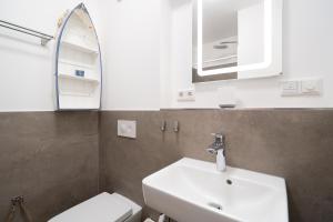 a bathroom with a sink and a toilet and a mirror at Steife Brise Nr 2 in Neustadt in Holstein +22 photos