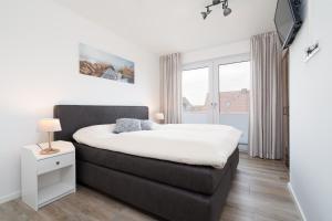 a bedroom with a large bed and a window at Steife Brise Nr 2 in Neustadt in Holstein