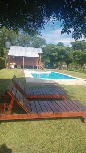 a wooden bench sitting next to a swimming pool at Kapo TEAM , colibri in Villa Amancay