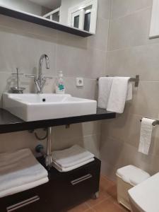 a bathroom with a sink and white towels at Apartamento centrico en Calella in Calella +17 photos