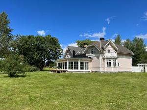 a large white house with a large yard at Rosa Huset Osebol in Stöllet