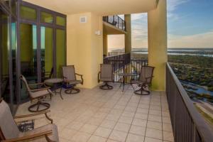 a balcony of a building with chairs and tables at The Oasis At Orange Beach 2215 by Liquid Life in Orange Beach