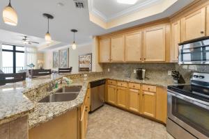 a kitchen with wooden cabinets and granite counter tops at The Oasis At Orange Beach 2215 by Liquid Life in Orange Beach