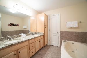 a bathroom with a tub and a sink and a bath tub at The Oasis At Orange Beach 2215 by Liquid Life in Orange Beach