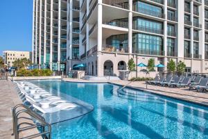 a swimming pool with lounge chairs in front of a building at The Oasis At Orange Beach 2215 by Liquid Life in Orange Beach