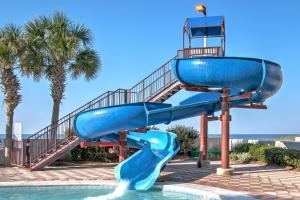 a blue water slide next to a pool at The Oasis At Orange Beach 2215 by Liquid Life in Orange Beach