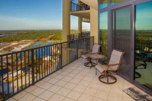 a balcony with two chairs and a view of the ocean at The Oasis At Orange Beach 2215 by Liquid Life in Orange Beach