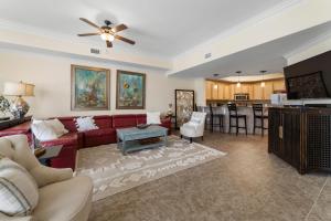a living room with a red couch and a kitchen at The Oasis At Orange Beach 2215 by Liquid Life in Orange Beach