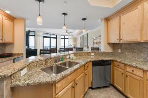 a kitchen with wooden cabinets and a sink at The Oasis At Orange Beach 2215 by Liquid Life in Orange Beach