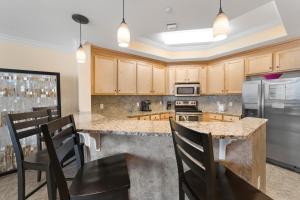 a kitchen with wooden cabinets and a counter top at The Oasis At Orange Beach 2215 by Liquid Life in Orange Beach
