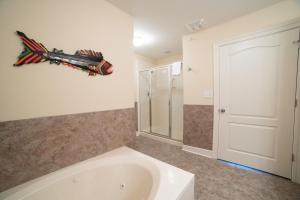 a bathroom with a bath tub with a fish on the wall at The Oasis At Orange Beach 2215 by Liquid Life in Orange Beach