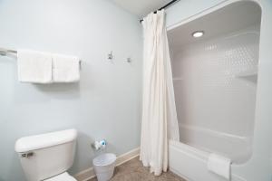 a white bathroom with a toilet and a shower at The Oasis At Orange Beach 2215 by Liquid Life in Orange Beach