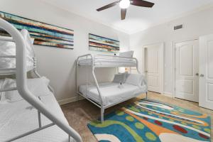 a bedroom with a bunk bed and a ceiling fan at The Oasis At Orange Beach 2215 by Liquid Life in Orange Beach +37 photos