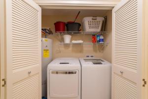 a small utility room with a washer and dryer at The Oasis At Orange Beach 2215 by Liquid Life in Orange Beach