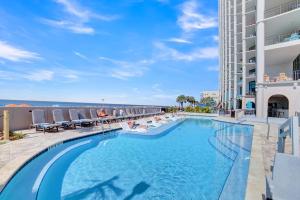 a swimming pool with lounge chairs and a building at The Oasis At Orange Beach 2215 by Liquid Life in Orange Beach