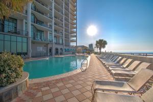 a swimming pool with chaise lounge chairs next to a building at The Oasis At Orange Beach 2215 by Liquid Life in Orange Beach