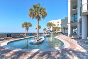 a swimming pool with a palm tree in the middle at The Oasis At Orange Beach 2215 by Liquid Life in Orange Beach