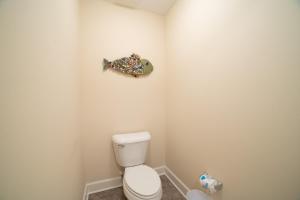 a bathroom with a toilet and a fish on the wall at The Oasis At Orange Beach 2215 by Liquid Life in Orange Beach