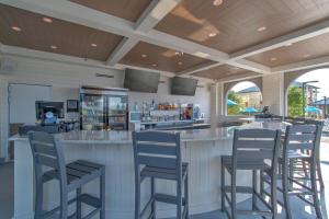 a bar with bar stools in a restaurant at The Oasis At Orange Beach 2215 by Liquid Life in Orange Beach