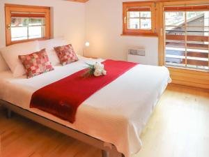 ツェルマットにあるHoliday Home Gädi by Interhomeのベッドルーム(花の飾られた白い大型ベッド付)