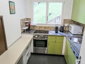 a kitchen with a stove and a sink and a window at Apartment Ringstrasse - Utoring-38 by Interhome in Leukerbad