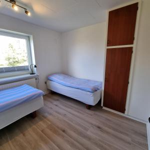维泽桑讷House in Hvide Sande Centrum的有两张床和一扇窗户的小房间