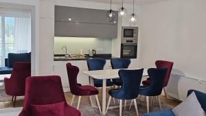 a kitchen and dining room with a table and chairs at Orange Apartment in Sarajevo