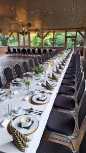 a long table with chairs and plates on it at Pensjonat U Kota Wasyla in Chodzież