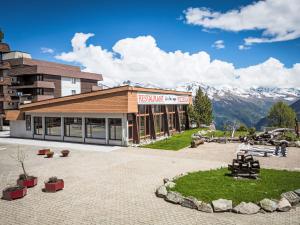 a resort building with mountains in the background at Studio Résidence Greppon by Interhome in Les Collons