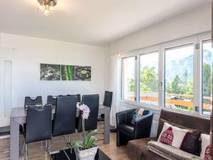 Una sala de estar con un sofá, una mesa y sillas. en Apartment Les Arolles A1 by Interhome, en Nendaz