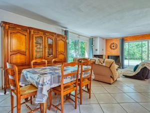 a dining room with a table and chairs and a couch at Holiday Home Tina by Interhome in Naujac-sur-Mer