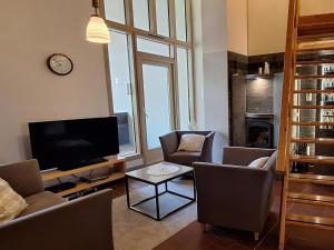 un salon avec des chaises, une télévision et une table dans l'établissement Holiday Home Hiisiranta e4 by Interhome, à Kolinkylä