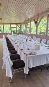 a long table with white tables and chairs in a room at Pensjonat U Kota Wasyla in Chodzież