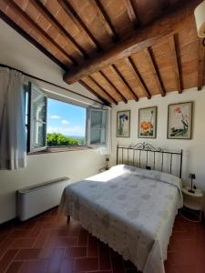 a bedroom with a bed and a large window at Castello di Fulignano Leonardo apartment ground floor in San Gimignano
