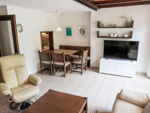 un soggiorno con un tavolo e una televisione di Apartment Ringstrasse - Utoring-50 by Interhome a Leukerbad
