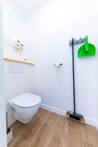 La salle de bains est pourvue de toilettes et d'une serpillière verte. dans l'établissement Les Amarres 6 pers Dunes et Mer Blériot plage, à Sangatte