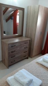 Un dormitorio con una cómoda con un espejo encima. en Χristinas loft, en Parga