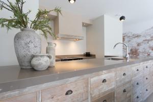 a kitchen with a counter with a vase and a sink at Zeayou Zeeland - Studio's Zuidstraat 1 in Domburg +26 photos