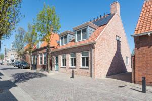 a brick building on a cobblestone street at Zeayou Zeeland - Studio's Zuidstraat 1 in Domburg
